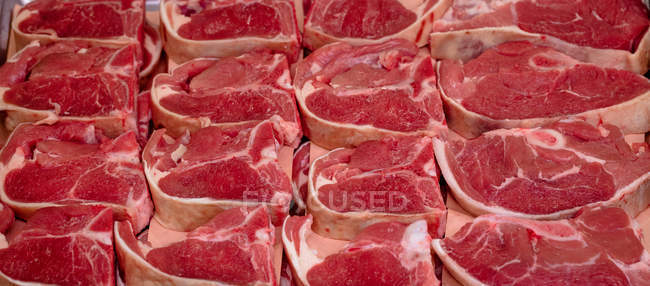 Крупный план сырых стейков в мясной лавке — стоковое фото