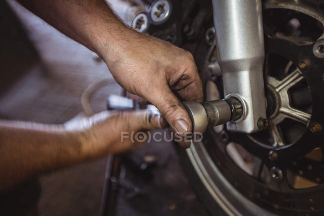 Mecánico examinando freno de disco moto en el taller - foto de stock