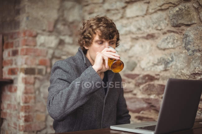 Man using laptop at bar — Stock Photo