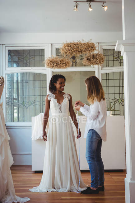 Modedesignerin interagiert mit Frau, während sie im Atelier Maß nimmt — Stockfoto