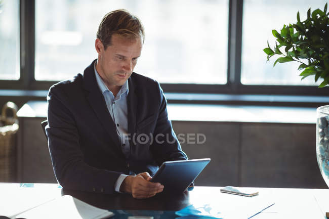 Concentrated businessman using digital tablet in office — Stock Photo