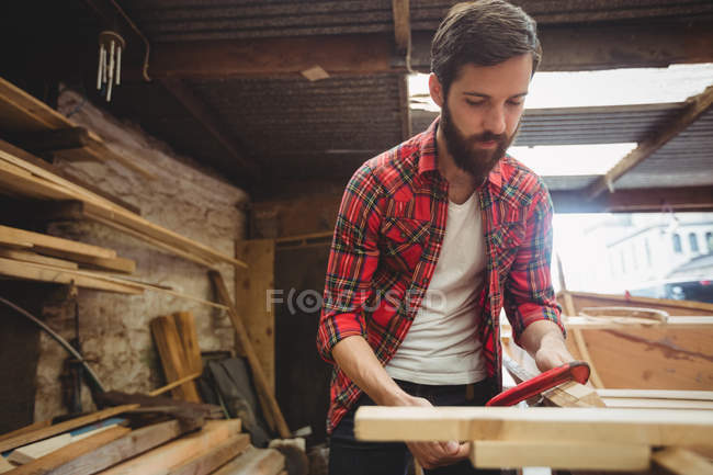 Homme préparant le cadre de bateau en bois dans le chantier naval — Photo de stock