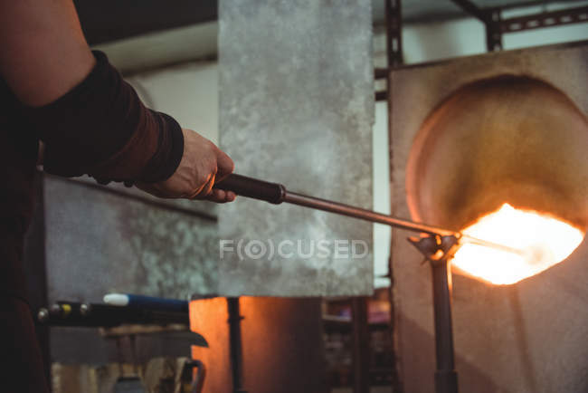 Immagine ritagliata del vetro di riscaldamento soffiatore in forno presso la fabbrica di soffiaggio vetro — Foto stock
