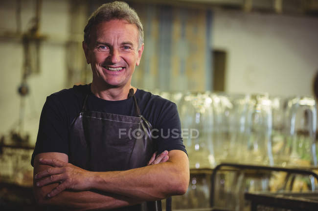 Ritratto di soffiatore di vetro con le braccia incrociate nella fabbrica di soffiaggio del vetro — Foto stock