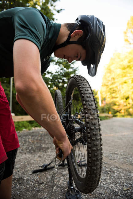 Homme cycliste réparer son vélo dans la forêt par une journée ensoleillée — Photo de stock