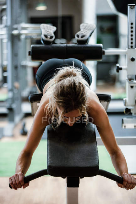Frau turnt im Fitnessstudio beim Bankdrücken — Stockfoto