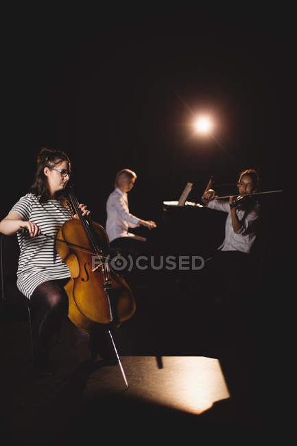 Three female students playing double bass, violin and piano in a studio — Stock Photo