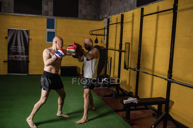 Полная длина двух тайских боксеров, практикующих в тренажерном зале — стоковое фото