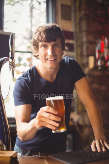 Портрет мужчины, держащего стакан пива в баре — стоковое фото