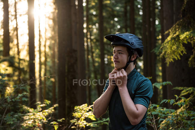 Casque de vélo sportif masculin en forêt — Photo de stock