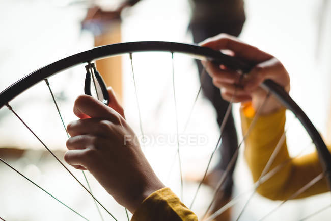 Mechaniker begutachtet in Werkstatt ein Fahrradrad — Stockfoto