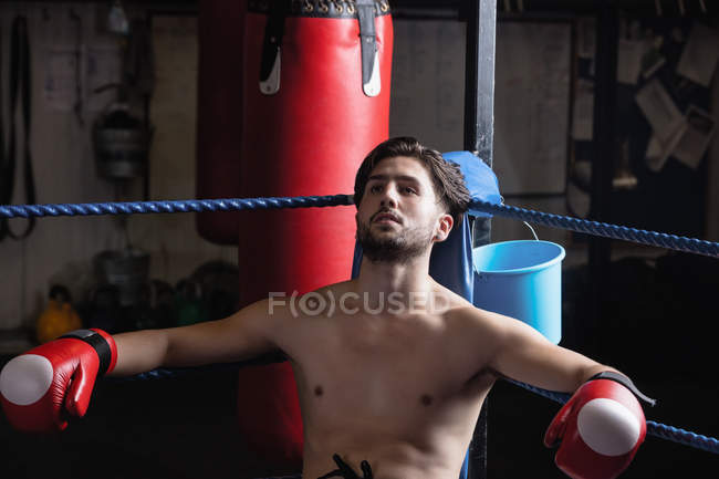 Beau boxeur fatigué reposant sur le ring de boxe — Photo de stock