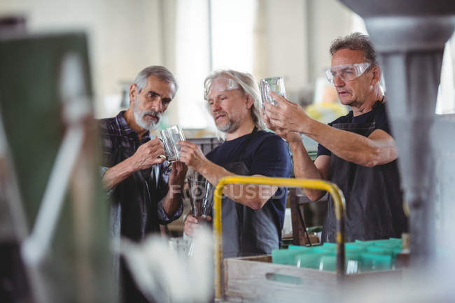 Glasbläser interagieren bei der Untersuchung der Glasvase in der Glasbläserei — Stockfoto