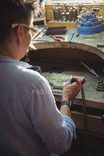 Craftswoman using blow torch in workshop — Stock Photo