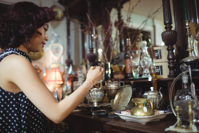 Stilvolle Frau kauft Antiquitäten im Antiquariat — Stockfoto