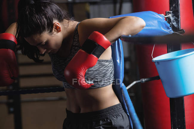 Female boxer taking break after practice in fitness studio — Stock Photo