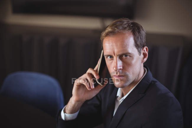 Portrait of a business man talking on the mobile phone in office — Stock Photo