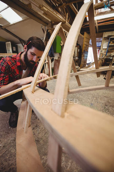 Mann bereitet auf Bootswerft einen Holzrahmen vor — Stockfoto
