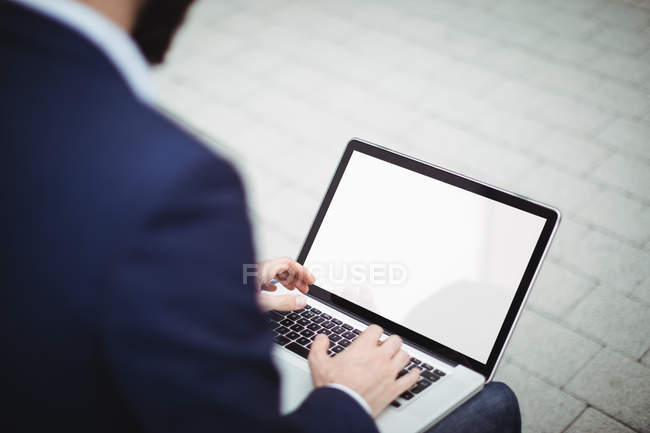 Primer plano del hombre de negocios utilizando el ordenador portátil fuera de la oficina - foto de stock