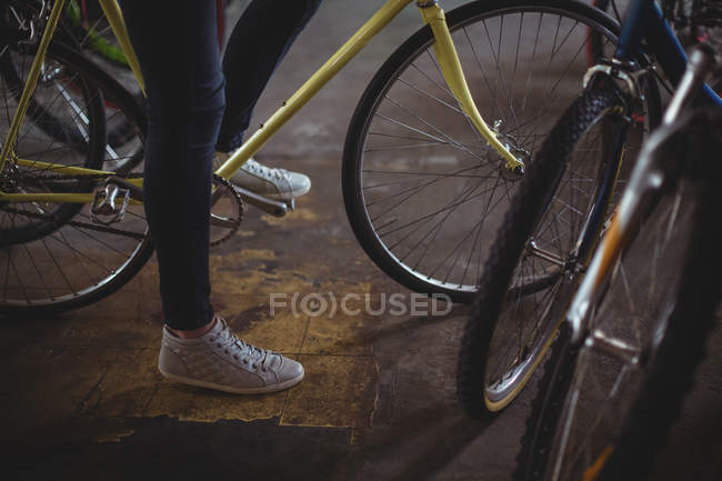 Meccanico cercando bicicletta in officina — Foto stock