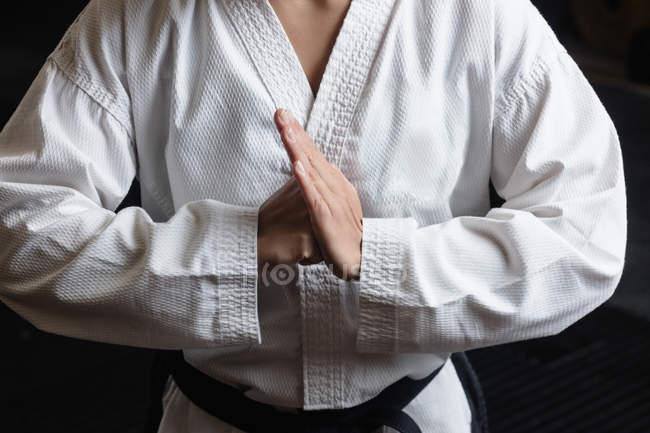 Sección media de la mujer practicando karate en el gimnasio - foto de stock