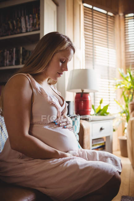 Femme enceinte se détendre dans le salon à la maison — Photo de stock