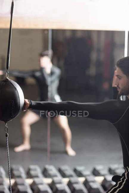 Boxer praticando boxe com saco de perfuração no estúdio de fitness — Fotografia de Stock