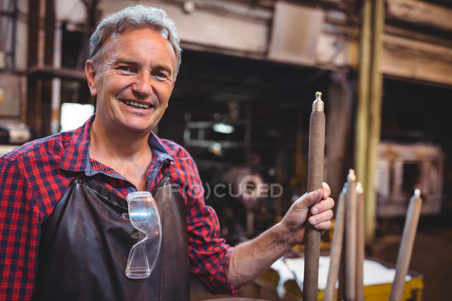 Retrato de soplador de vidrio que sostiene la tubería en la fábrica de soplado de vidrio - foto de stock