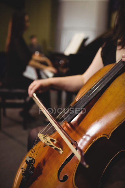 Metà sezione di studentessa che suona il contrabbasso in uno studio — Foto stock