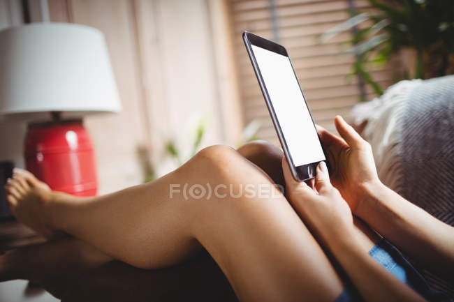 Жінка використовує цифровий планшет у вітальні вдома — стокове фото