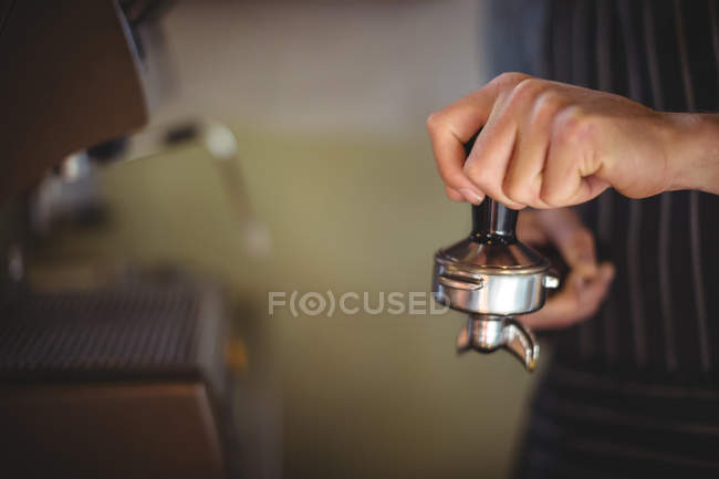 Mid section of waiter using a tamper in cafe at workshop — Stock Photo
