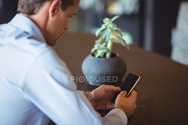 Концентрований бізнесмен за допомогою мобільного телефону в ресторані — стокове фото