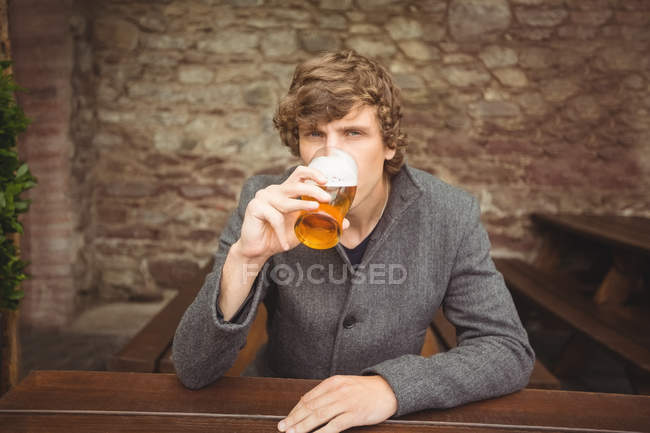 Retrato de homem tomando um copo de cerveja no bar — Fotografia de Stock