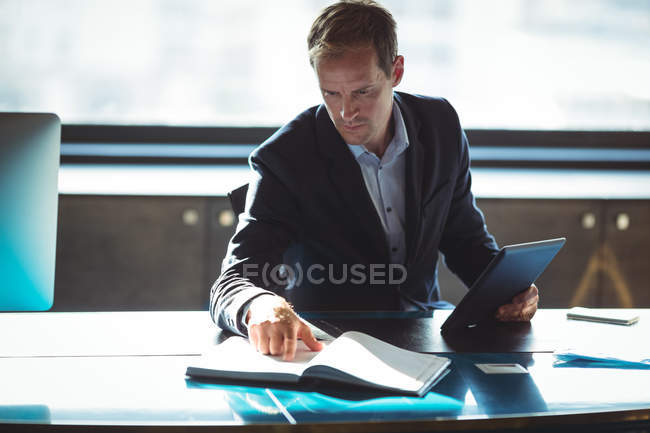 Бізнесмен перевіряє свій щоденник, використовуючи цифровий планшет в офісі — стокове фото