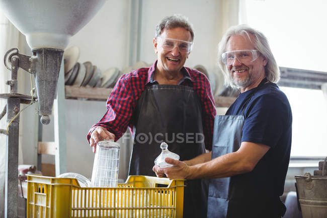 Портрет скляних пилососів, що тримають скляний посуд на заводі — стокове фото