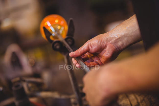 Hands of glassblower shaping a molten glass at glassblowing factory — Stock Photo
