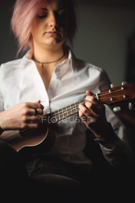 Woman playing a guitar in music school — Stock Photo