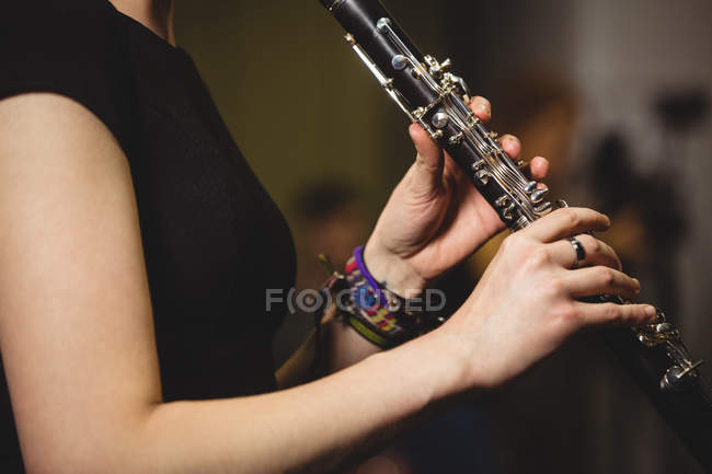 A meio de uma sessão de estudante a tocar clarinete num estúdio — Fotografia de Stock