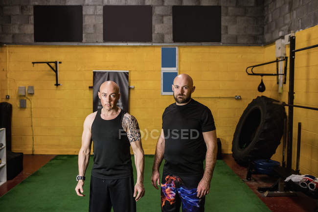 Портрет впевнених тайських боксерів, що стоять у спортзалі і дивляться на камеру — стокове фото