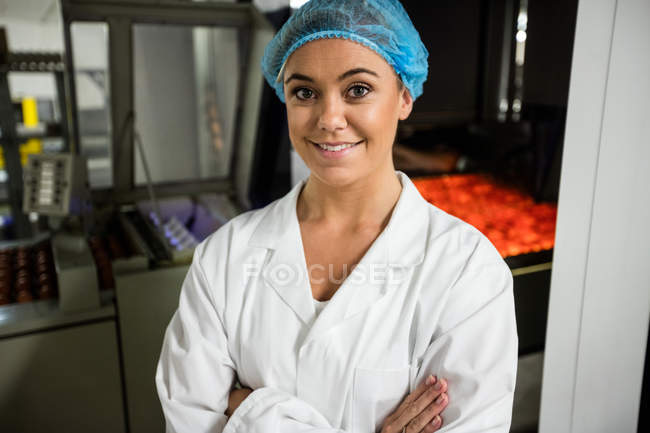 Retrato del personal femenino de pie con los brazos cruzados en la fábrica de huevos - foto de stock