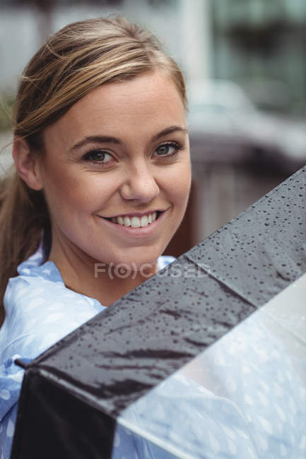 Портрет красивої жінки, що тримає парасольку і дивиться на камеру — стокове фото