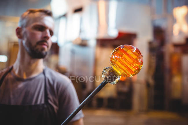 Soplador de vidrio que forma un vidrio fundido en la fábrica de soplado de vidrio - foto de stock