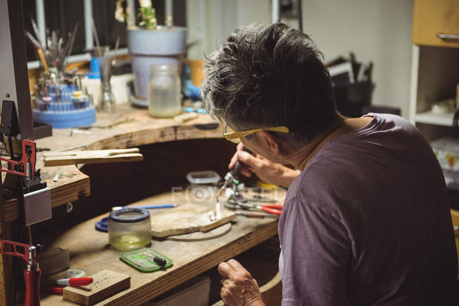 Handwerker mit Taschenlampe in Werkstatt — Stockfoto