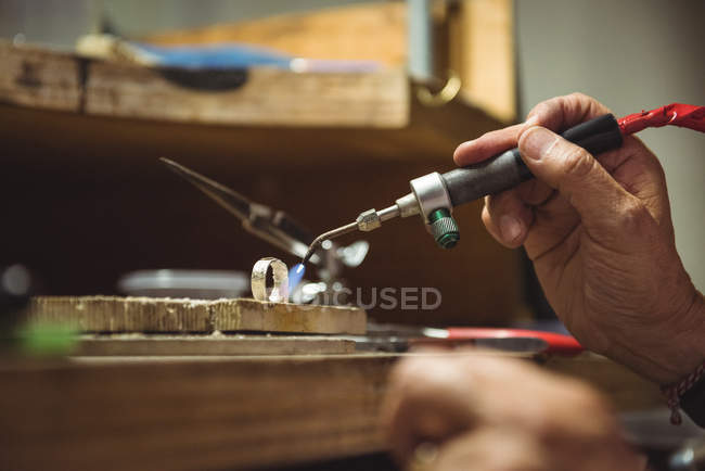 Руки ремесленницы с помощью паяльника в мастерской — стоковое фото