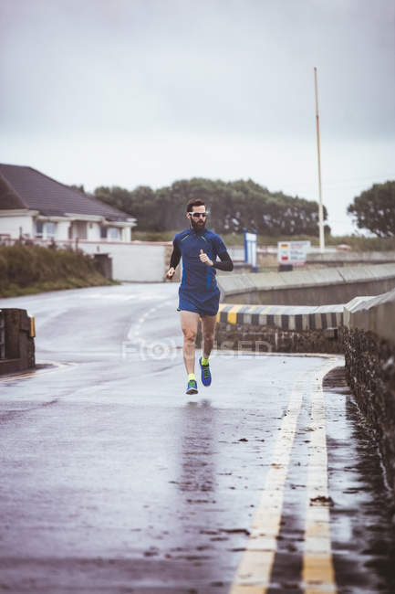 Спортсмен біжить по дорозі протягом дня — стокове фото