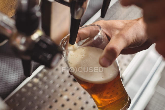 Nahaufnahme des Bartenders, der Bier von der Zapfsäule an der Theke füllt — Stockfoto