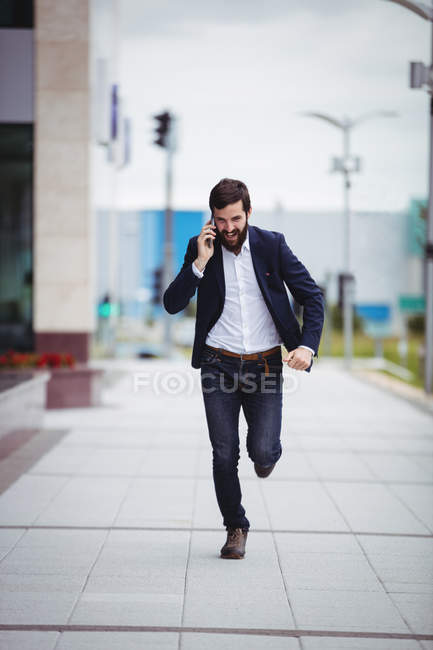 Empresário correndo enquanto fala no celular — Fotografia de Stock
