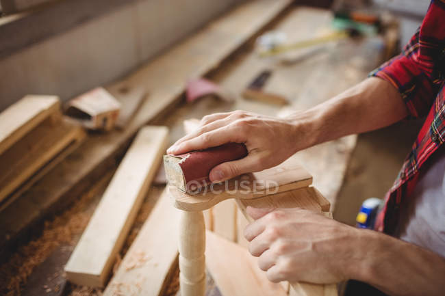 Man working over a wooden plank at boatyard — Stock Photo
