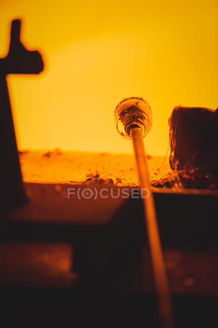 Close-up of a piece of glass heated in furnace at glassblowing factory — Stock Photo