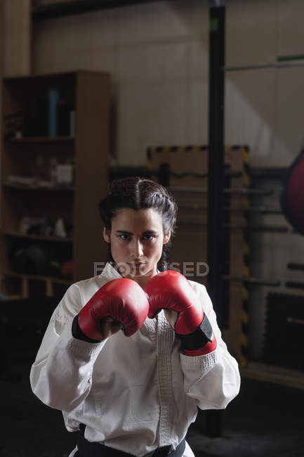 Portrait of woman in boxing gloves at fitness studio — Stock Photo